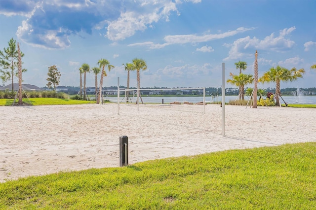 view of home's community with a water view and volleyball court