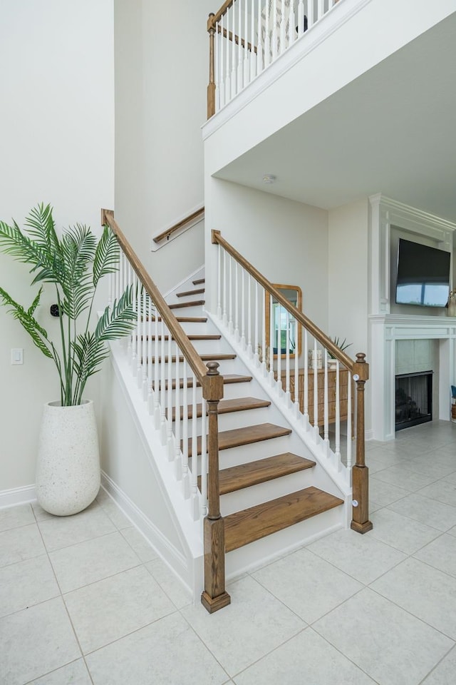 staircase featuring tile patterned floors and a fireplace