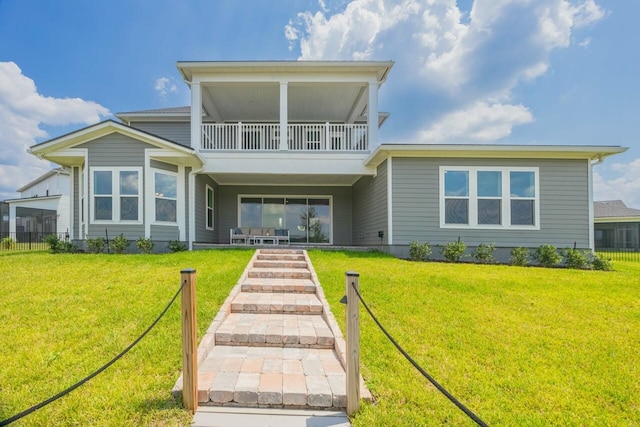 back of house with a yard and a balcony