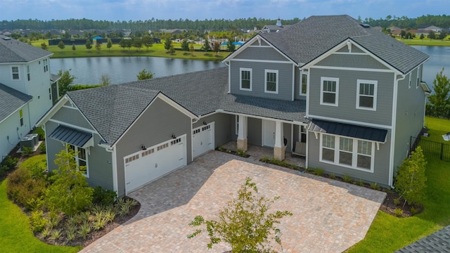 craftsman inspired home with cooling unit, a water view, and a garage