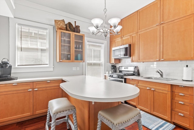 54 Grove Ave, Saint Augustine, FL 32084 - kitchen featuring stainless steel appliances, a kitchen breakfast bar, a sink, light countertops, and backsplash