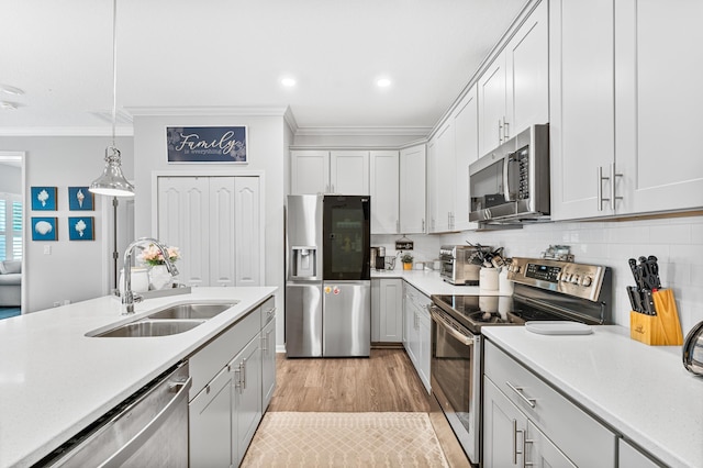 313 Aventurine Ave, Saint Augustine, FL 32086 - kitchen featuring appliances with stainless steel finishes, ornamental molding, light countertops, hanging light fixtures, and backsplash
