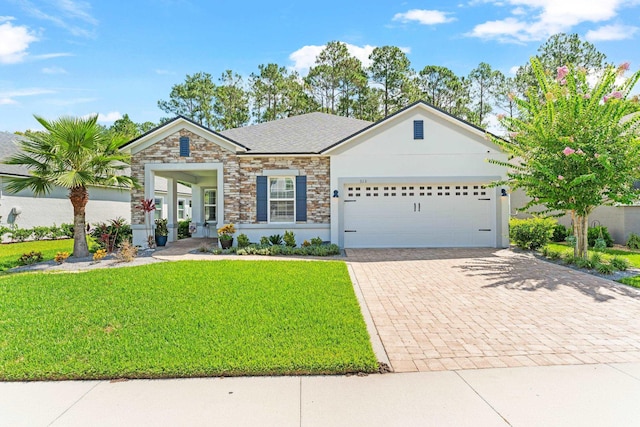 313 Aventurine Ave, Saint Augustine, FL 32086 - view of front of house featuring stone siding, an attached garage, decorative driveway, a front yard, and stucco siding