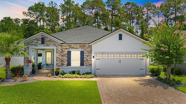 313 Aventurine Ave, Saint Augustine, FL 32086 - view of front of house featuring stone siding, a garage, decorative driveway, roof with shingles, and a front yard