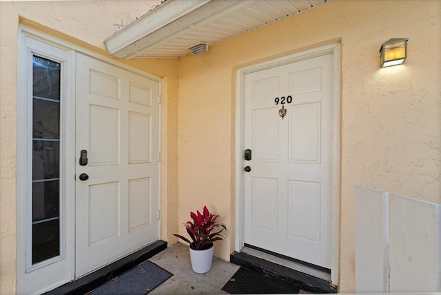 doorway to property featuring stucco siding