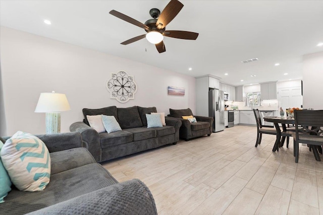 living room with visible vents, recessed lighting, light wood-style floors, and ceiling fan