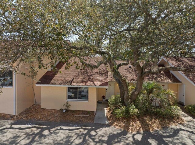 exterior space with roof with shingles and stucco siding