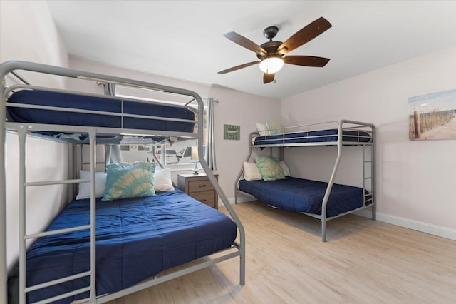 bedroom featuring wood finished floors, baseboards, and ceiling fan