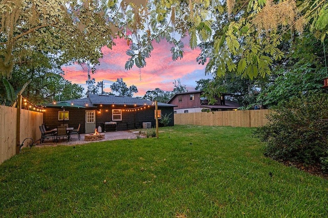 yard at dusk featuring a patio