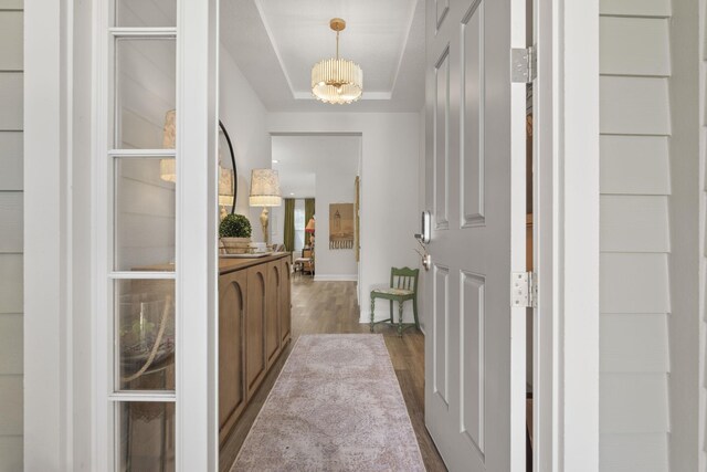 corridor featuring an inviting chandelier and light hardwood / wood-style flooring