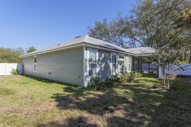 view of side of home with a lawn and a sunroom