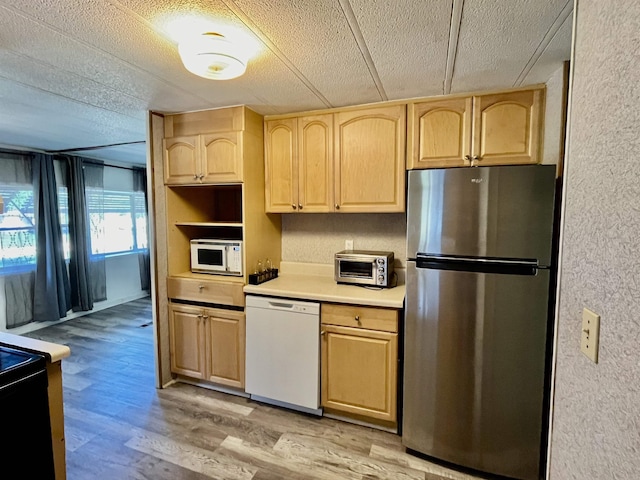 kitchen featuring a textured ceiling, light brown cabinets, light hardwood / wood-style floors, and white appliances