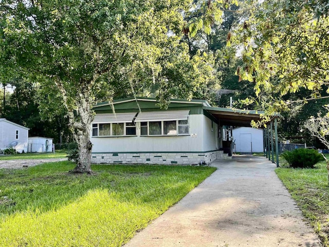 manufactured / mobile home featuring a carport and a front lawn