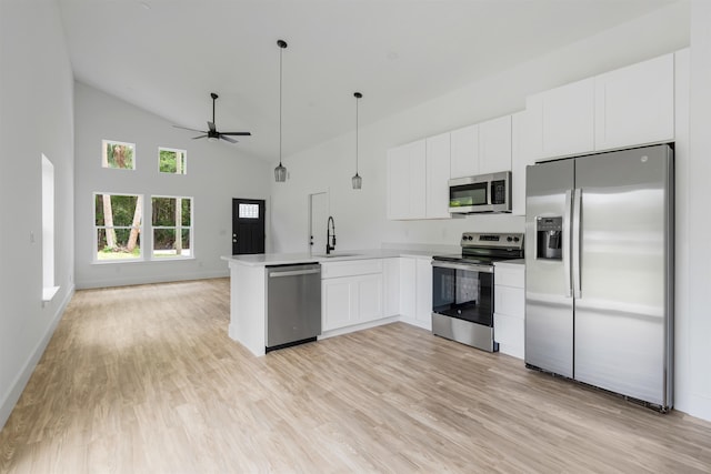 kitchen with kitchen peninsula, light wood-type flooring, stainless steel appliances, and white cabinets