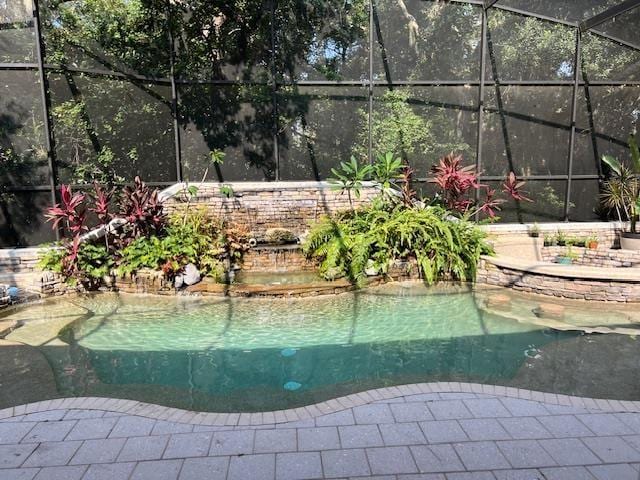 view of swimming pool with glass enclosure