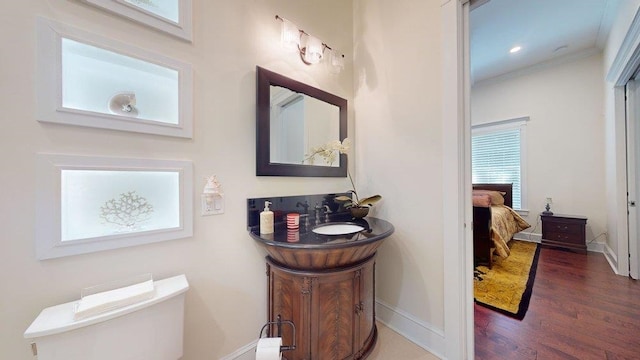 bathroom with wood-type flooring, vanity, toilet, and ornamental molding