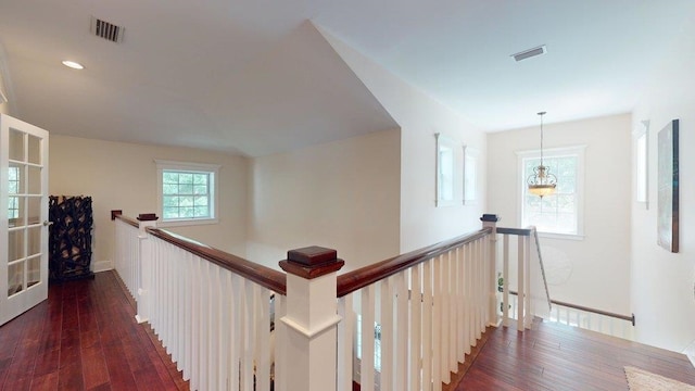 hallway featuring dark hardwood / wood-style flooring and a chandelier