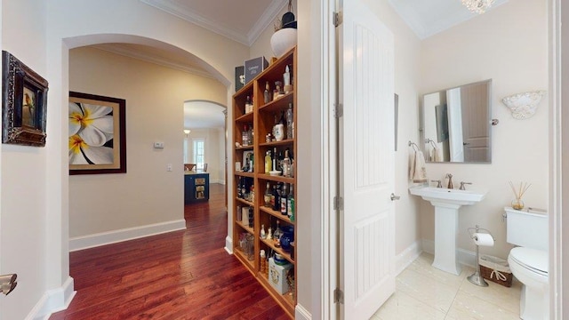 hall with wood-type flooring and ornamental molding