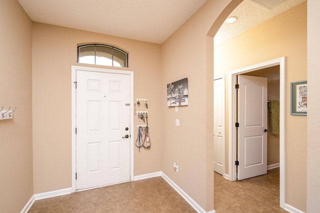 tiled entryway featuring a textured ceiling