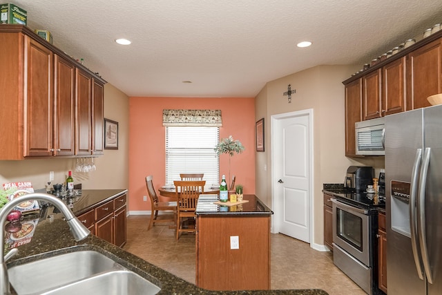 kitchen featuring sink, a kitchen island, stainless steel appliances, and a textured ceiling