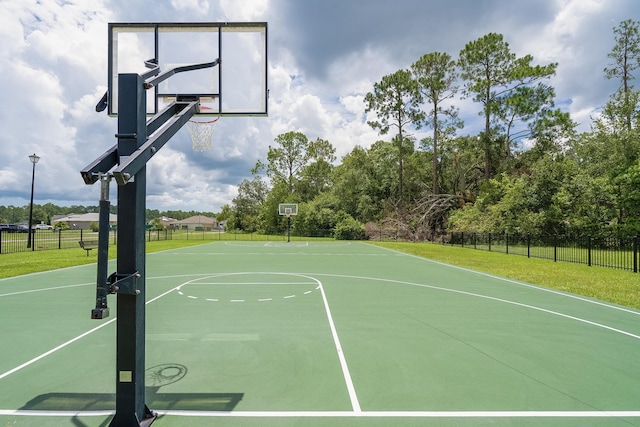 view of basketball court with a yard