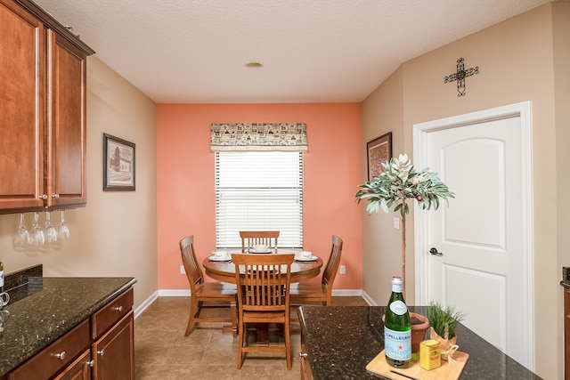 tiled dining area with a textured ceiling