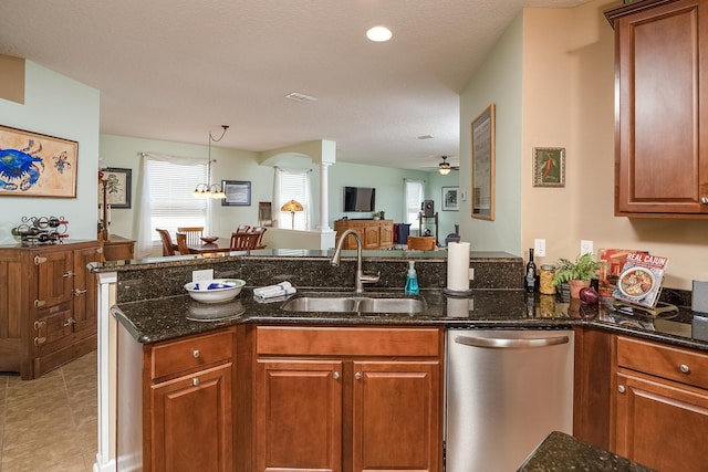 kitchen featuring kitchen peninsula, dark stone counters, ceiling fan with notable chandelier, sink, and dishwasher