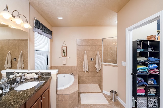 bathroom featuring tile patterned floors, vanity, separate shower and tub, and a textured ceiling