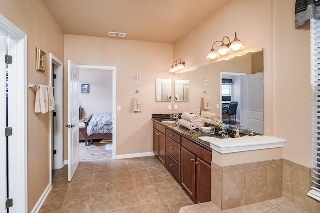 bathroom with tile patterned floors, vanity, and a textured ceiling