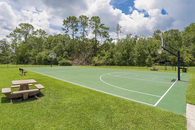 view of sport court featuring a lawn