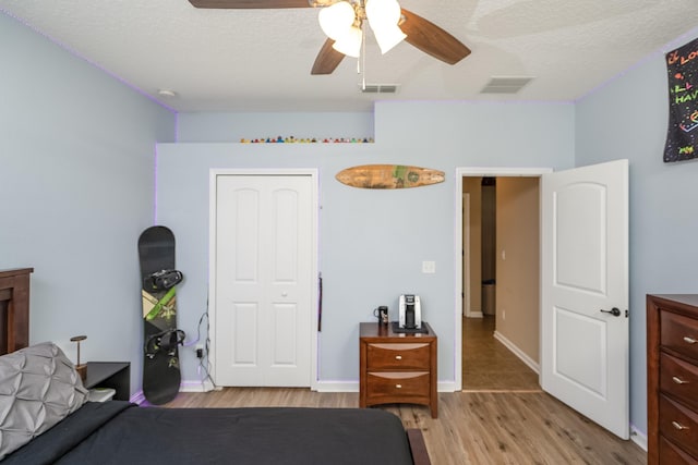 bedroom featuring a textured ceiling, light hardwood / wood-style floors, and ceiling fan