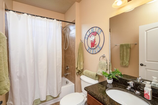 full bathroom with vanity, shower / tub combo, a textured ceiling, and toilet