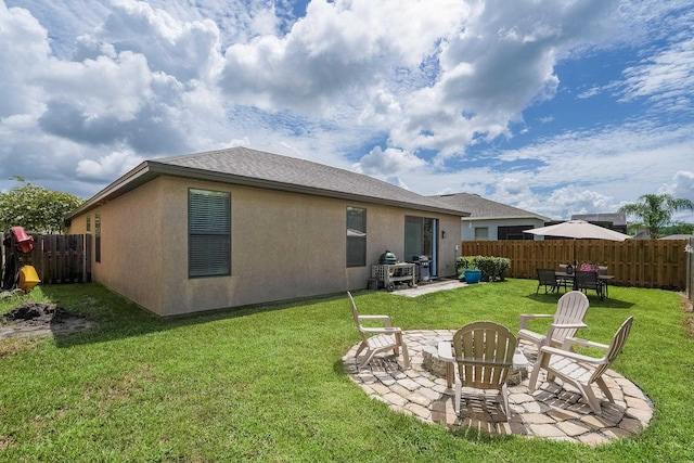 back of house with a lawn, an outdoor fire pit, and a patio