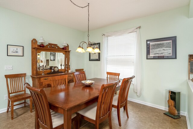 tiled dining space with a chandelier