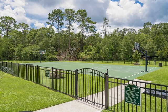 view of basketball court with a yard