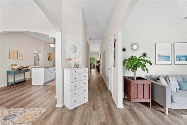 775 E Red House Branch Rd, Saint Augustine, FL 32084 - corridor featuring arched walkways, light wood-type flooring, baseboards, and a textured ceiling