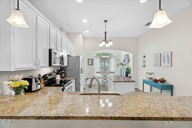 775 E Red House Branch Rd, Saint Augustine, FL 32084 - kitchen with stainless steel appliances, a chandelier, light stone counters, a sink, and white cabinetry