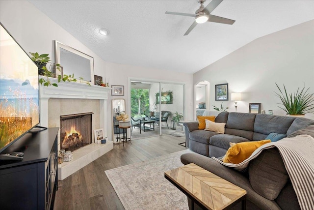 775 E Red House Branch Rd, Saint Augustine, FL 32084 - living area with vaulted ceiling, ceiling fan, a lit fireplace, arched walkways, and dark wood-style flooring