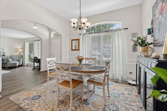 775 E Red House Branch Rd, Saint Augustine, FL 32084 - dining area with arched walkways, a chandelier, wood finished floors, and wainscoting