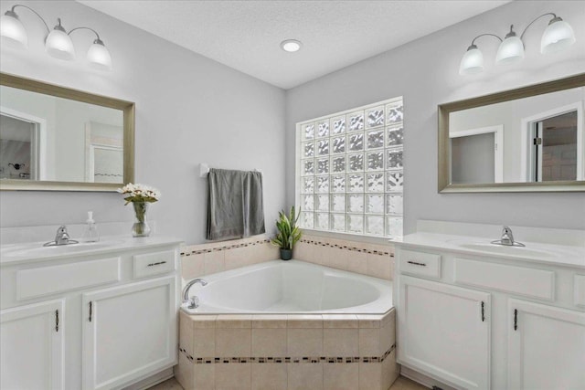 775 E Red House Branch Rd, Saint Augustine, FL 32084 - bathroom featuring two vanities, a garden tub, and a textured ceiling