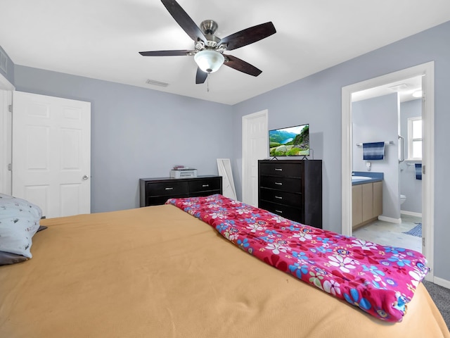 carpeted bedroom with baseboards, connected bathroom, and ceiling fan