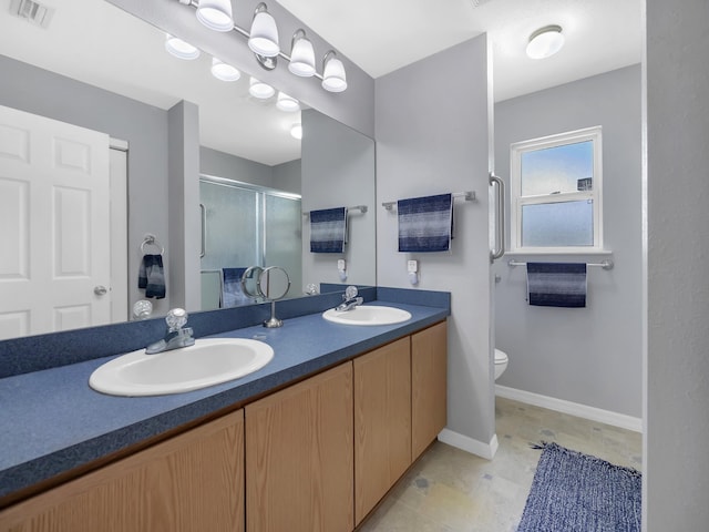 full bath featuring a stall shower, toilet, double vanity, and baseboards