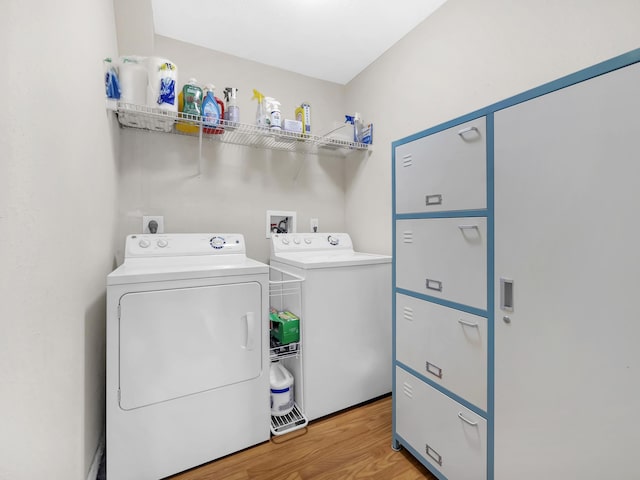laundry room with washer and dryer and light wood-style floors