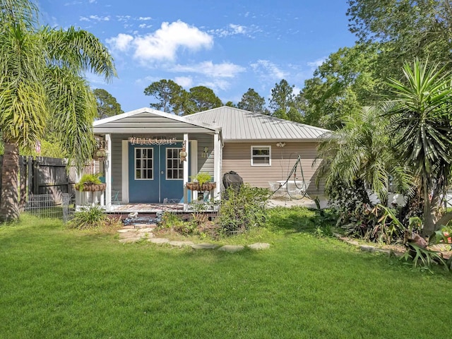rear view of property featuring covered porch and metal roof