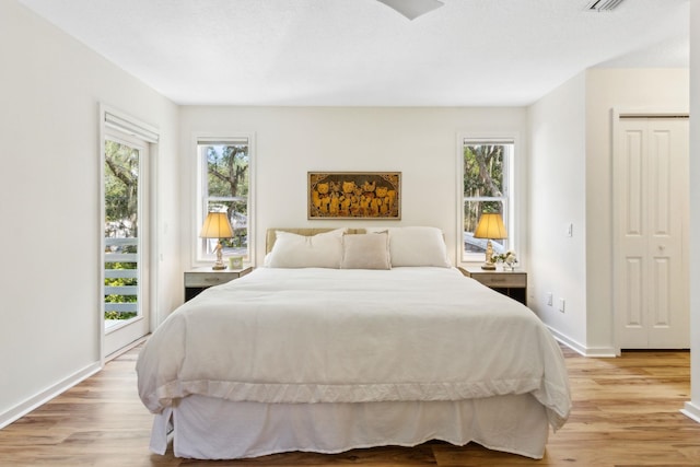 136 Island Hammock Way, Saint Augustine, FL 32080 - bedroom featuring access to outside, multiple windows, light wood-style floors, and baseboards