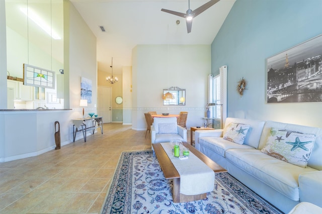 tiled living room featuring ceiling fan with notable chandelier and high vaulted ceiling