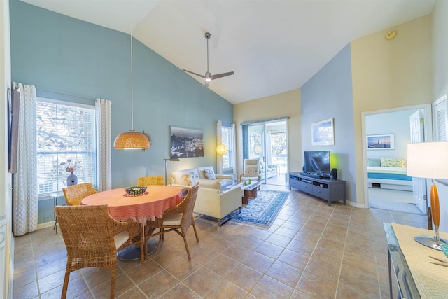 dining space with ceiling fan, high vaulted ceiling, and light tile patterned floors