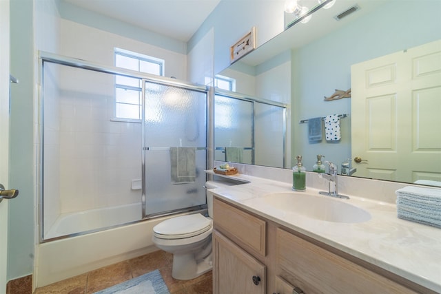 full bathroom with tile patterned flooring, vanity, shower / bath combination with glass door, and toilet