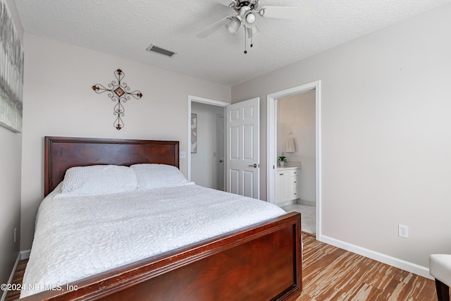 841 S County Road 13, Saint Augustine, FL 32092 - bedroom with a textured ceiling, light wood-type flooring, ensuite bath, and ceiling fan