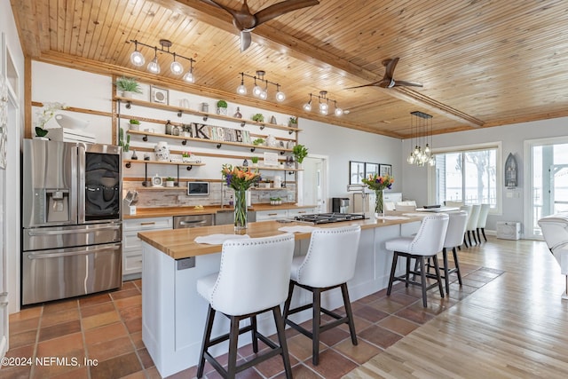841 S County Road 13, Saint Augustine, FL 32092 - kitchen with ceiling fan, wooden ceiling, stainless steel appliances, wood counters, and a breakfast bar area